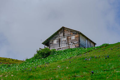 Abandoned house on field against sky