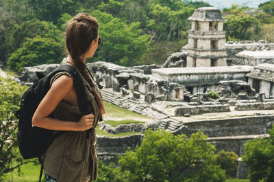 Rear view of woman standing against building