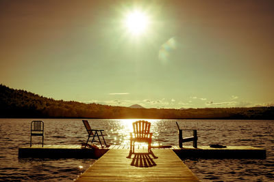 Pier on lake at sunset