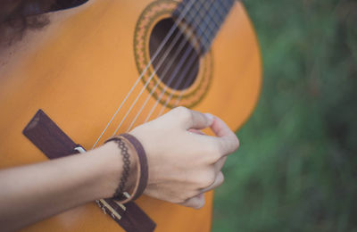 Cropped hand of woman playing guitar