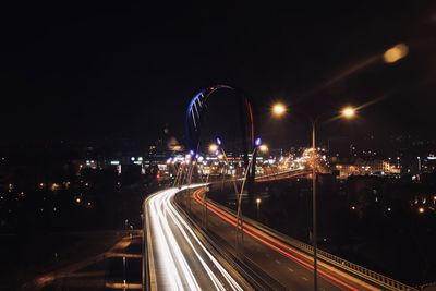 Light trails on road against sky at night