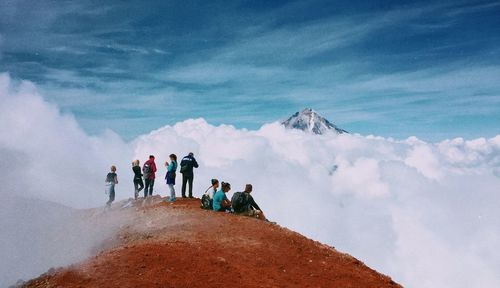 People on mountain against sky