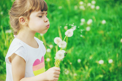 Portrait of girl blowing flowers