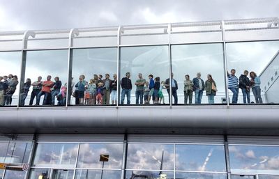 Group of people waiting for train against sky