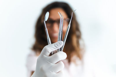 Close-up of woman holding hands against white background