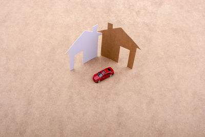 High angle view of toy car with cardboard model homes on table