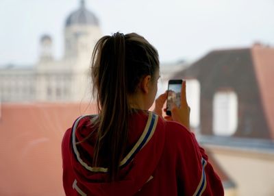 Rear view of woman standing against built structure