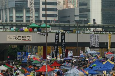 People on street against buildings in city