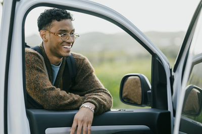 Smiling man leaning on van door