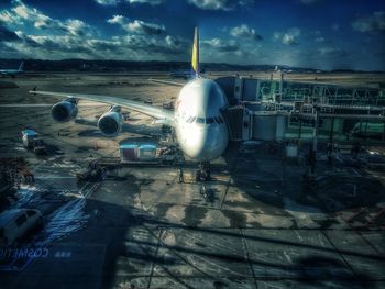 Airplane on airport runway against sky