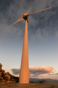 Low angle view of windmill on field against sky during sunset