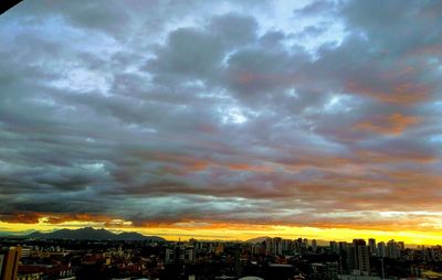 Aerial view of cityscape against dramatic sky