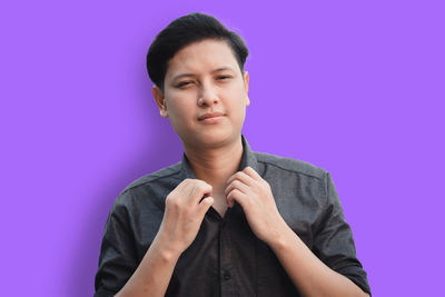 Portrait of young man against pink background
