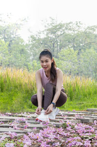 Portrait of smiling young woman sitting by plants