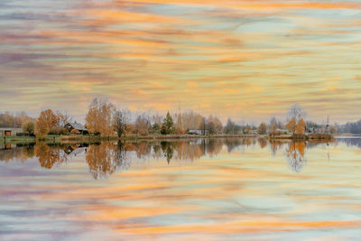 Reflection of trees in lake against sky during sunset