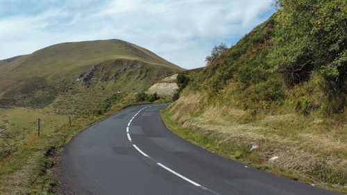 Empty road by mountain against sky