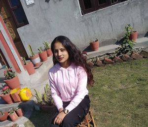 Portrait of smiling young woman sitting outdoors