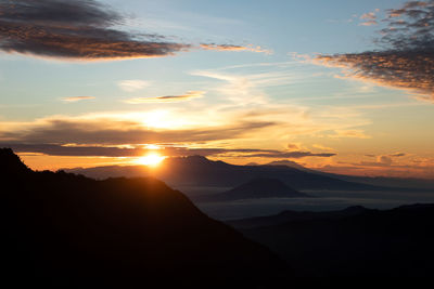 Scenic view of silhouette mountains against sky during sunset