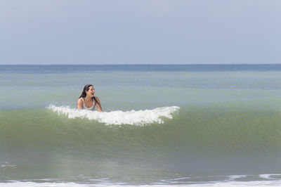 Young woman surfboarding in sea