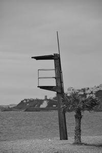 Lifeguard hut by sea against sky