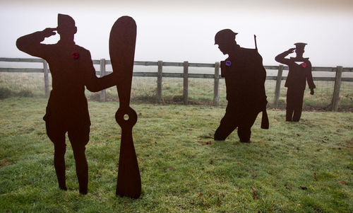 People standing on field against sky