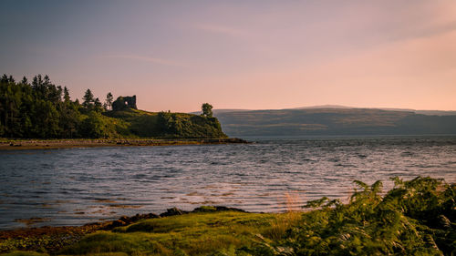 Scenic view of lake against sky at sunset