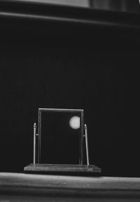 Close-up of camera on table against black background