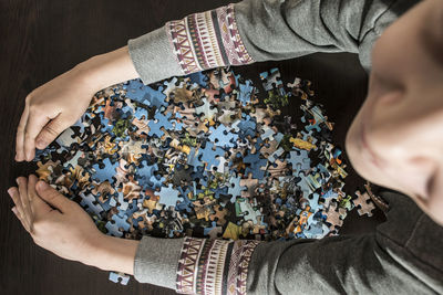 High angle view of child with jigsaw pieces