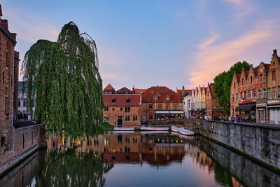 Panoramic view of buildings by river against sky