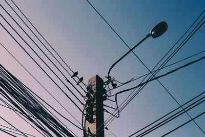 Low angle view of electricity pylon against sky