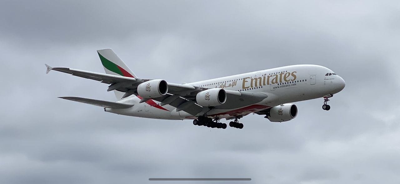 LOW ANGLE VIEW OF AIRPLANE AGAINST CLOUDY SKY