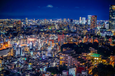 Illuminated cityscape against sky at night