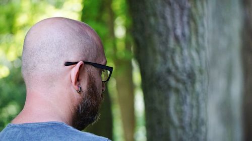 Rear view of bald man by tree in park