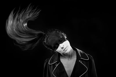 Portrait of young man against black background