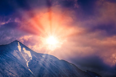 Scenic view of snowcapped mountains against sky during sunset