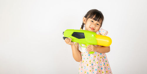 Portrait of young woman holding bottle against white background