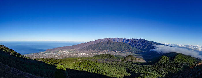 Scenic view of mountains against clear blue sky