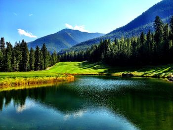 Scenic view of river by mountains against sky