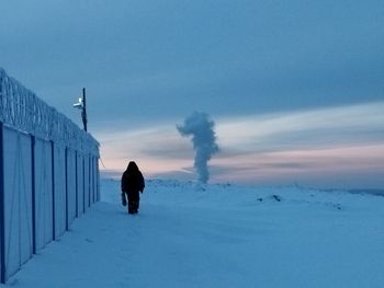 Rear view of person standing on snow covered landscape