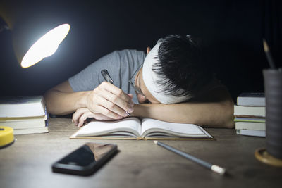 Midsection of man reading book on table