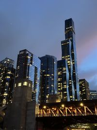 Low angle view of illuminated buildings against sky at night