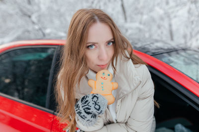 Portrait of beautiful woman holding cookie in car