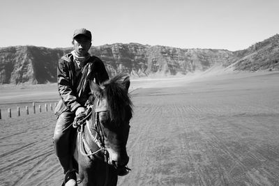 Portrait of man riding horse against sky