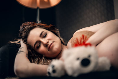Portrait of young woman with teddy bear
