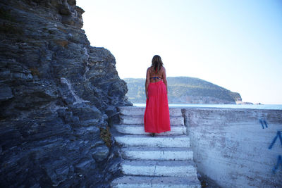 Rear view of woman standing against mountain