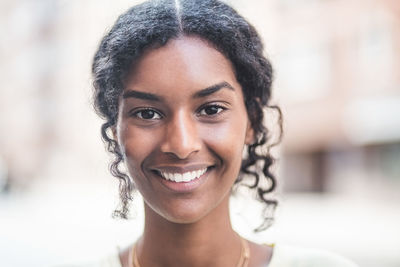 Portrait of smiling young woman in city