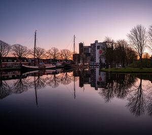 Reflection of bridge in river against sky