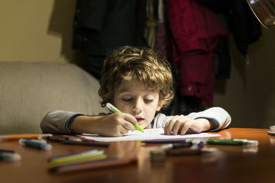 Boy drawing on paper at home