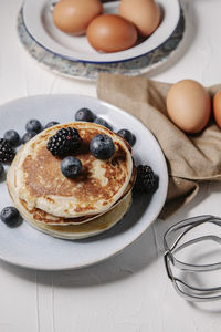 Stack of pancakes with berries, still life overhead shot.