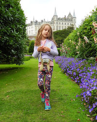 Portrait of smiling young woman standing against plants